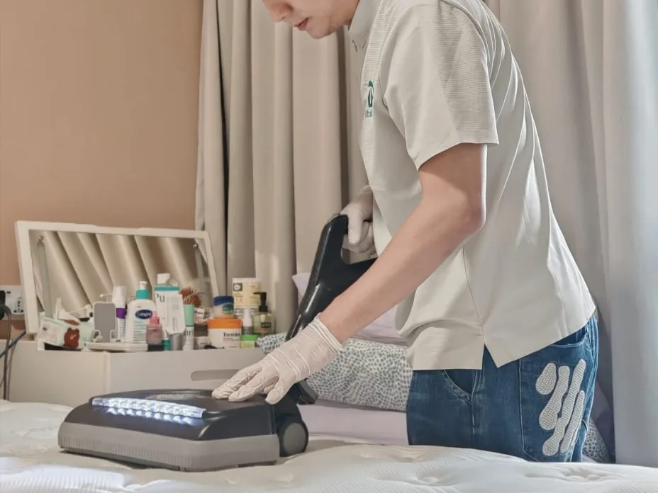 Upholstery scrubber running across a mattress surface