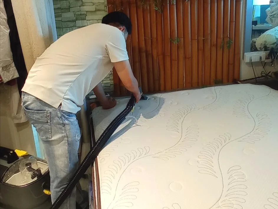 Mattress cleaning in front of a wooden headboard