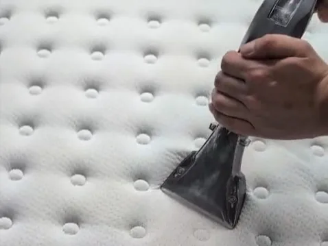 Close-up of an extraction tool lifting dirt from a mattress